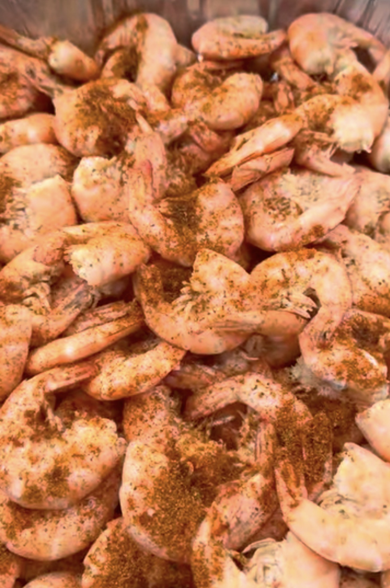Close-up of a bushel of steamed shrimp heavily coated in Louisiana-style seasoning
